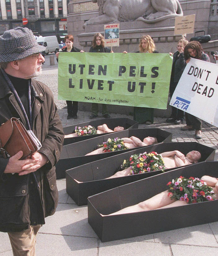  Fire demonstranter kledde mandag formiddag av seg foran Stortinget og la seg ned i “likkister" av papp for  protestere motpelseksport og bruk av pels. (Foto: Morten Holm, NTB Pluss)